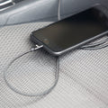 An iPhone charging cable charging an iPhone in a car